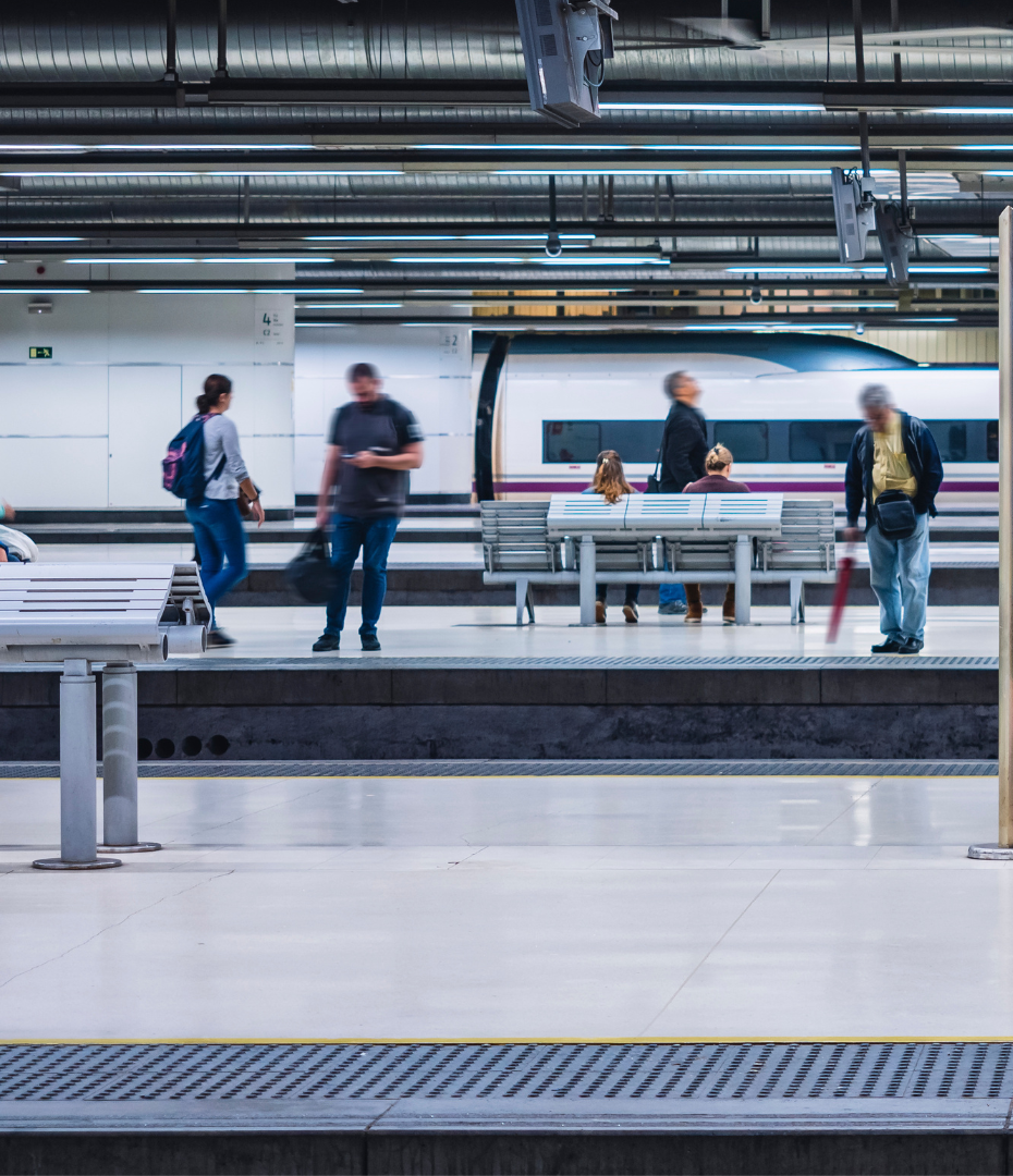 People waiting at a train station with a modern train in the background