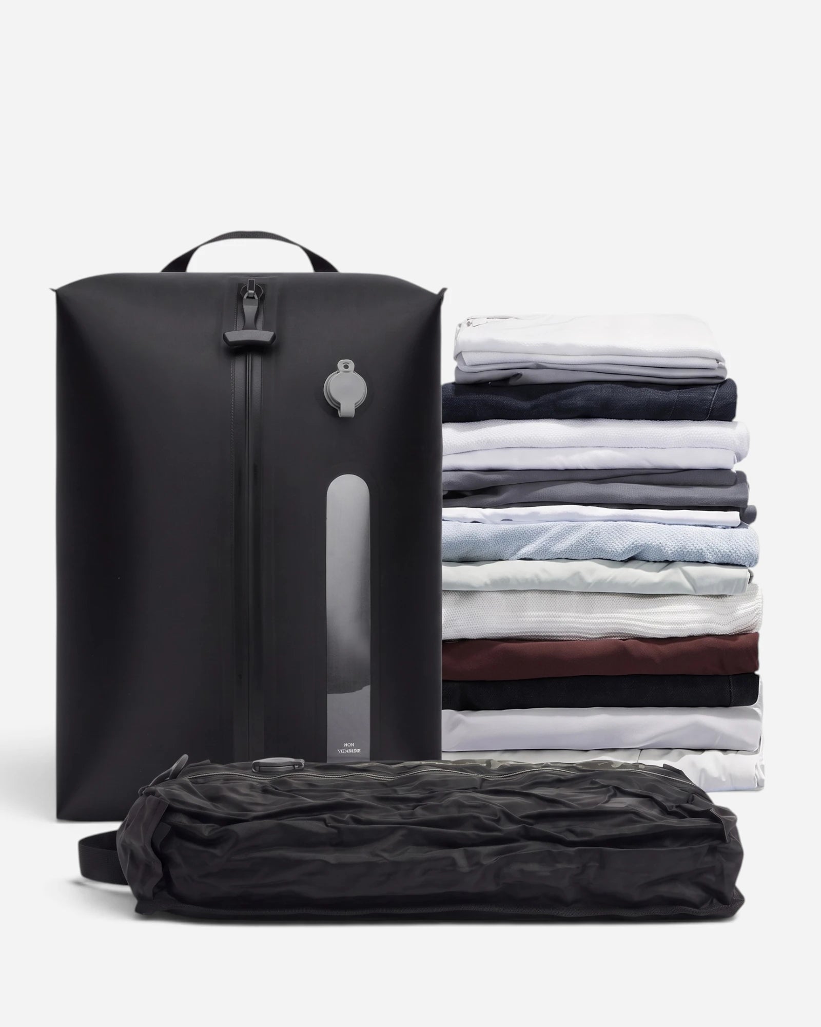 Lavnex Still Vac™ Jet Black vacuum compression bag shown upright next to flattened version and stack of folded clothes demonstrating space reduction