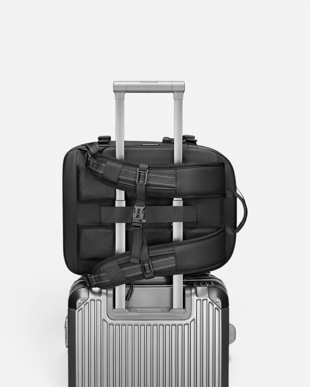Lavnex ZoraPack Mini™ Jet Black backpack attached to silver suitcase handle showing travel‑friendly design