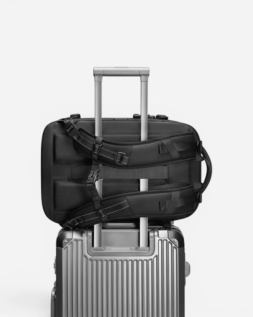Lavnex ZoraPack Pro backpack attached to silver suitcase handle for easy travel